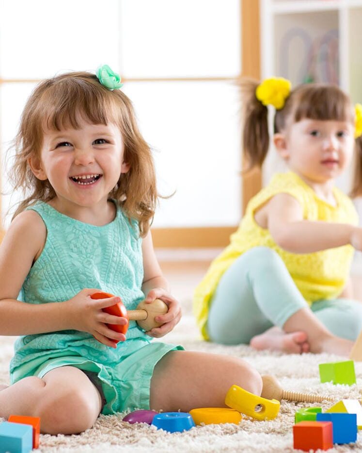 Creative Center children playing together on the classroom floor