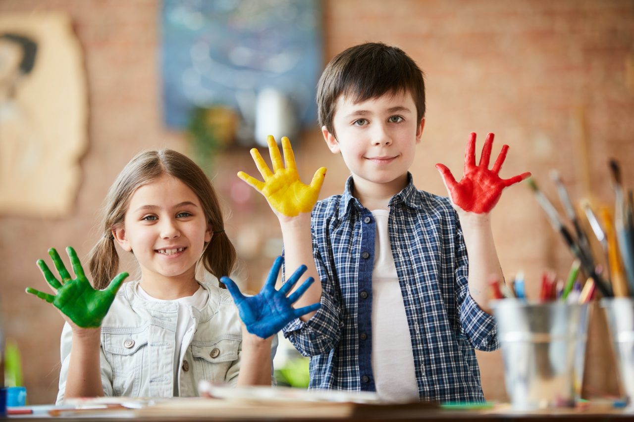 Children exploring colours with hand painting