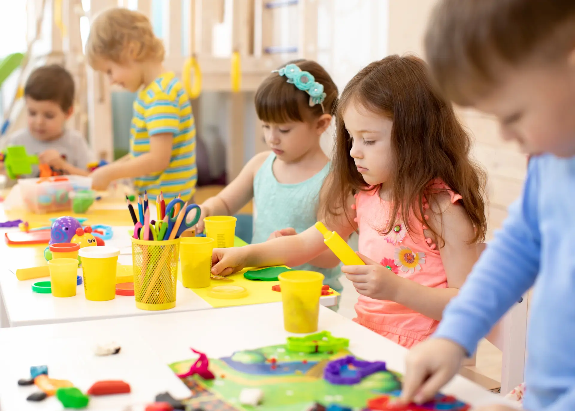 Children creating together around a classroom activity table